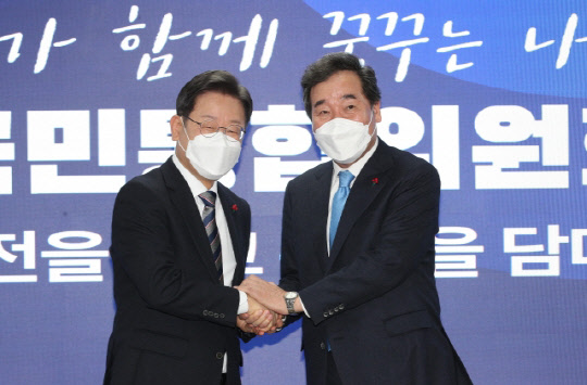 이재명(왼쪽) 더불어민주당 대선 후보와 이낙연 공동위원장이 27일 오전 서울 여의도 당사에서 열린 국가비전·국민통합위원회 출범식에 앞서 손을 잡고 있다. 국회사진기자단